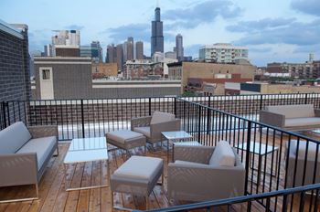 A balcony with a table and chairs overlooking a city skyline.